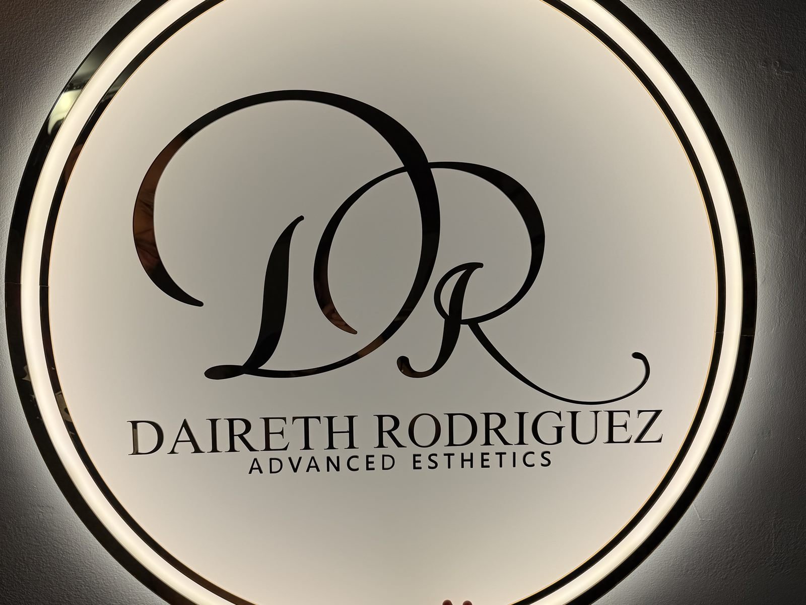 Backlit round acrylic sign for Daireth Rodriguez Advanced Esthetics