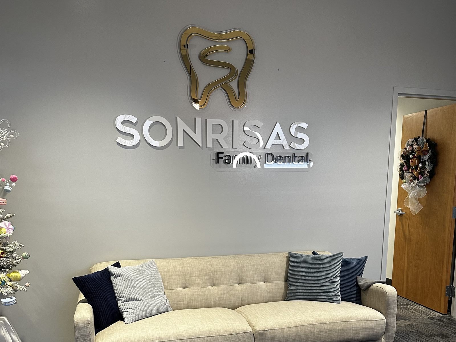 Dimensional logo installed on the reception wall of Sonrisas Family Dental